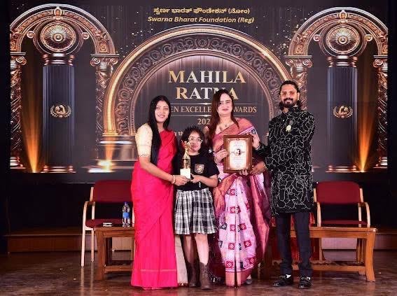 Dr. Chaitali Tamakuwala receiving the Mahila Ratna award plaque on stage